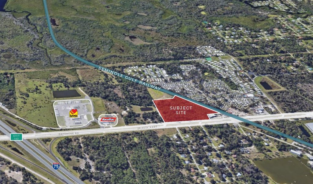 Aerial view of a triangular vacant lot labeled “Subject Site” bordered by a railway, near a truck stop and gas station, adjacent to Bayshore Road and Interstate 75 in a semi-rural area.