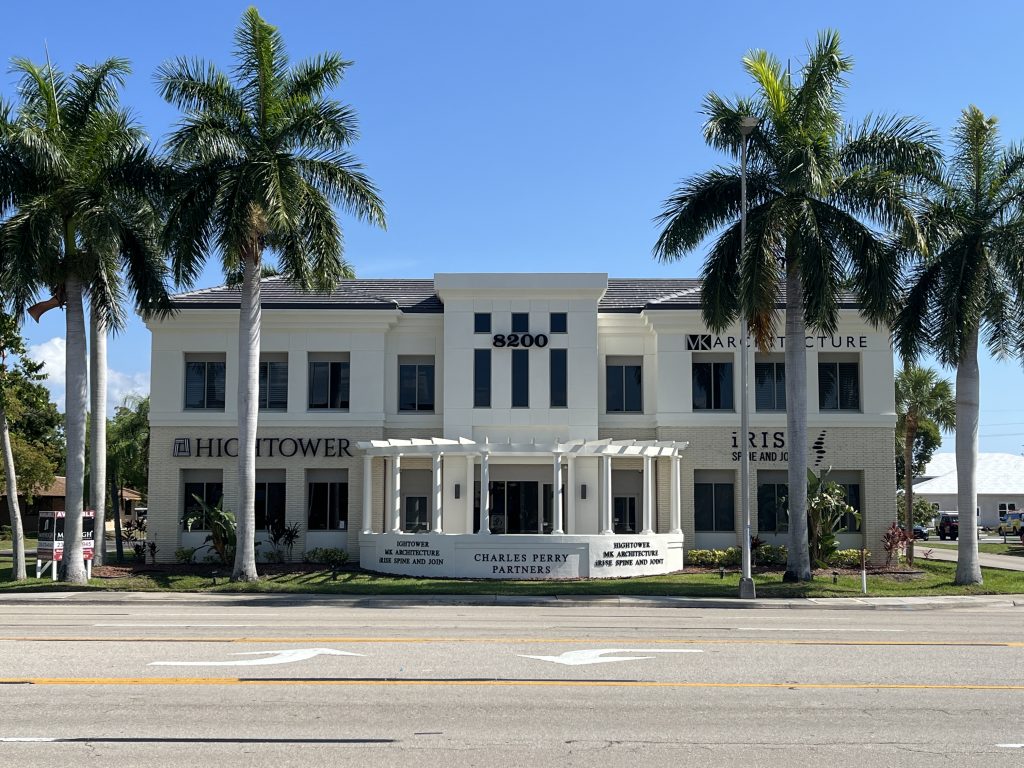 A two-story white office building labeled 8200, with palm trees in front, houses businesses including Hightower, Charles Perry Partners, and Warren Architecture.