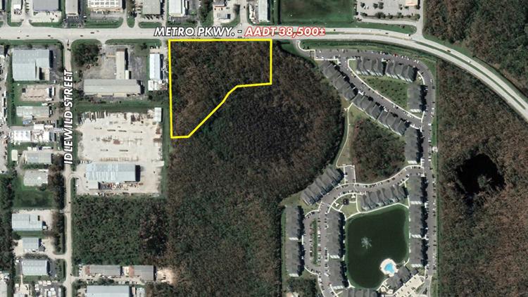 Aerial view of a wooded lot outlined in yellow near Metro Parkway and Idlewild Street, adjacent to residential and commercial areas, with traffic data labeled "AADT: 38,500±".